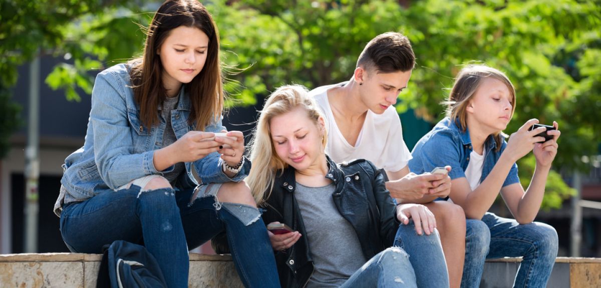 Teenagers using their smartphones.