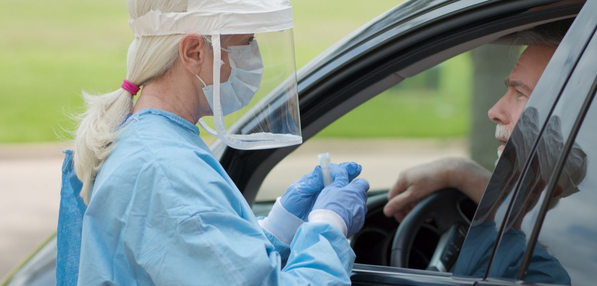Nurse testing a man in car for coronavirus