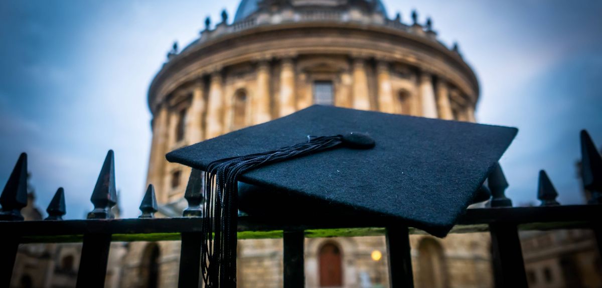 Image of a mortar board hanging on the railings outside Radcliffe Camera
