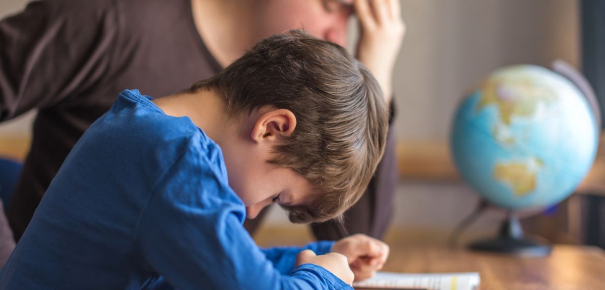 Stressed father trying to help son with schoolwork
