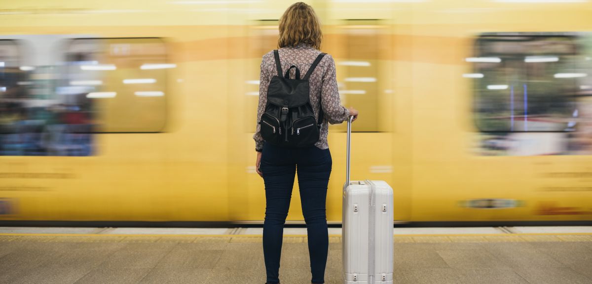 Woman waiting for a train, holding a suitcase