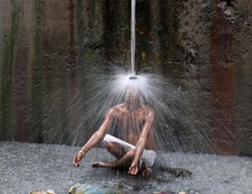Indian man under water spout