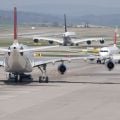 Three commercial passenger jets on an airport runway. wo moving away, one approaching. It looks like the aircrafts are deadlocked in a taxiway traffic jam.