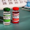 Mockup of two doses of a COVID-19 vaccine with needle