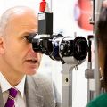 Professor Robert MacLaren examines a patient's eyes