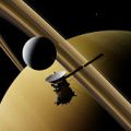 Saturn's moon Enceladus and spacecraft Cassini–Huygens in front of planet Saturn, rings and other moons (3D illustration, elements of this image are furnished by NASA)