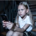 Unhappy girl using a smart phone: data shows girls experience a negative link between social media use and life satisfaction when they are 11-13 years old and boys when they are 14-15 years old. Credit: Shutterstock.
