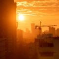 Mumbai, India - September 2022: Silhouette of a construction crane on a building at sunset with a skyline of the suburb of Kandivali in the background. Credit: Balaji Srinivasan