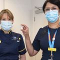 Photo | Nurses Sam Foster and Meghana Pandit display a vial of the Oxford coronavirus vaccine
