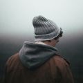 Man in hat and hoody outside in dark light. Photo by Andrew Neel on Unsplash