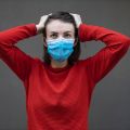 Woman in red sweater and mask. Photo by engin akyurt on Unsplash