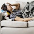 Woman laying on the couch sick with flu