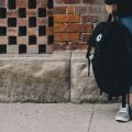 Student standing with a rucksack. Image credit: Scott Webb on Unsplash