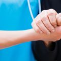 Nurse holding an elderly person's hand